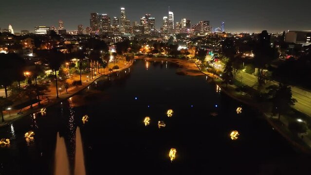 Aerial flyover of Echo Park in Downtown Los Angeles area at night, skyline of buildings