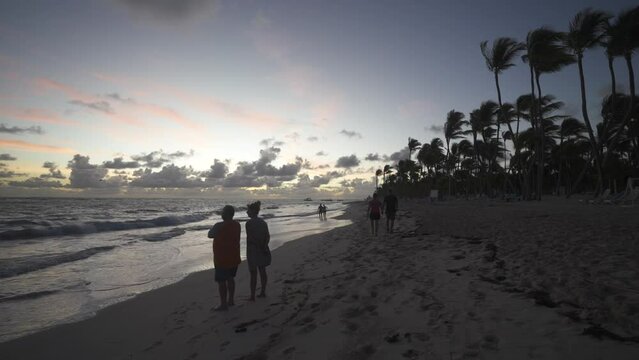 Couple walking on beach at sunrise, Bavaro Beach, Punta Cana, Dominican Republic, West Indies, Caribbean, Central America