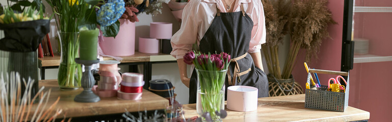 Obraz na płótnie Canvas happy professional woman is working in flower shop