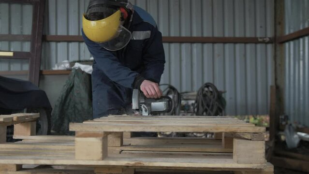 Man cuts pallet wood with a circular saw Medium Shot