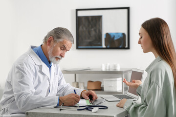 Obraz premium Professional orthopedist consulting patient at table in clinic