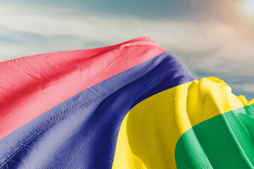 Mauritius national flag cloth fabric waving on beautiful grey sky.