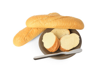 Whole and cut baguettes with fresh butter on white background, top view