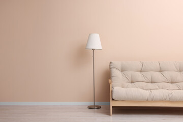 Comfortable sofa and stylish lamp indoors. Space for text