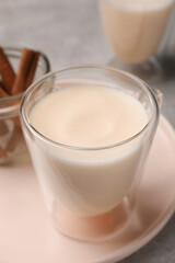 Delicious eggnog with cinnamon on light grey table