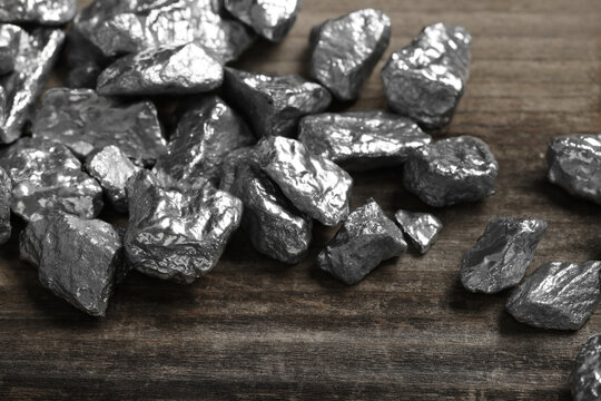 Pile of silver nuggets on wooden table, closeup