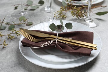 Stylish table setting with cutlery and eucalyptus leaves