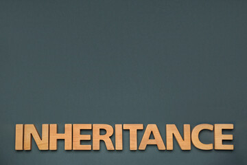 Word Inheritance made with wooden letters on grey background, flat lay. Space for text