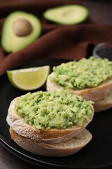 Delicious sandwiches with guacamole on black plate, closeup