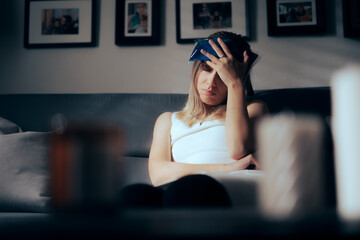 Sick Woman Using an Ice Bag o Alleviate Migraine. Unhappy person having a headache after physical...