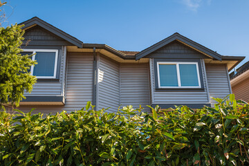 Top of a house with nice windows in the blue sky background. Beautiful Home Exterior. Real Estate Exterior Front House