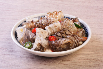 Cold fish skin in sauce in a bowl on a wooden table