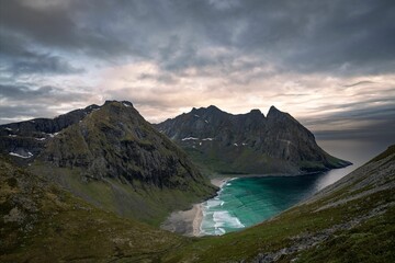 Naklejka premium Landscape of Kvalvika Beach surrounded by the sea on a stormy day in Norway