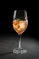 Vertical shot of a glass of Tasty Aperol juice cocktail on a black background