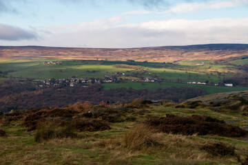 Beautiful view from the hill to the village in a green valley with farm fields, forest and horizon