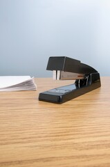 Vertical shot of a stapler on a wooden table