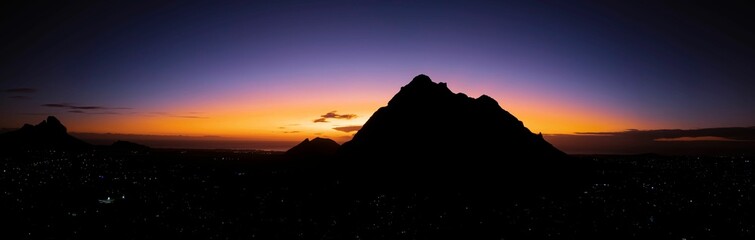 Panoramic shot of mountain silhouettes at a dramatic sunset