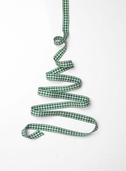 Vertical shot of a Christmas tree made of ribbons on a white background.