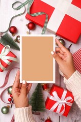 Vertical shot of an empty frame in a female hands over the Christmas decorations