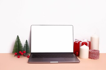 Christmas setup with decorations and blank notebook screen in the middle for mockup