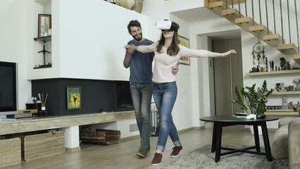 Young couple are trying new virtual reality device – special glasses for VR experience. Modern goggles allows user to watch 360 degrees video, animation or play interactive video game.