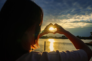 Heart hand finger in sunset landscape nature, Woman making heart shape with Hands