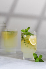 Lemonade with fresh lemon slices in a glass in the photo with a cinematic effect. Summer refreshing drink with lemon. 