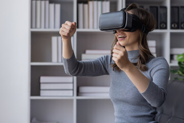 Surprised Young latin woman in VR headset touching air, Smiling white woman wearing vr glasses while sitting on sofa at home.