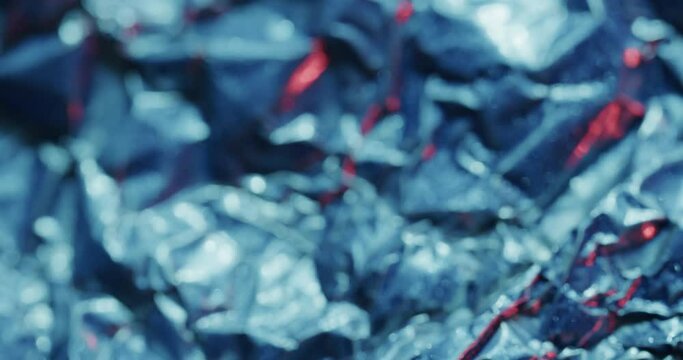 Close up of blue crumpled pieces of plastic material in slow motion