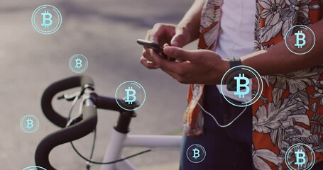 Animation of bitcoin icons, data processing over african american man using smartphone - Powered by Adobe