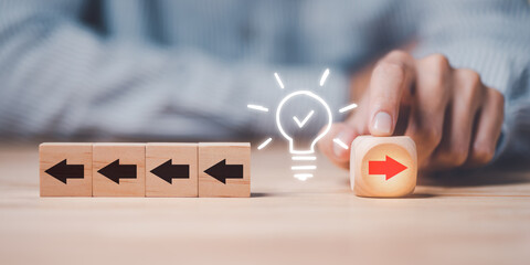 Businessman pointing at a wooden block with red arrow and different black,difference...