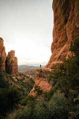 Fototapeta na wymiar Wide angle view of woman watching sunset in Sedona Arizona from Cathedral Rock Viewpoint.