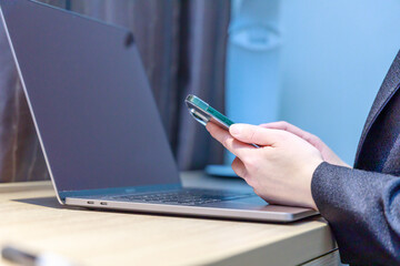 テレワークをしながらスマホを確認している女性