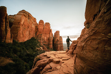 Horizontal wide angle view of woman standing at sunset from Cathedral Rock in Sedona. © ArboursAbroad.com