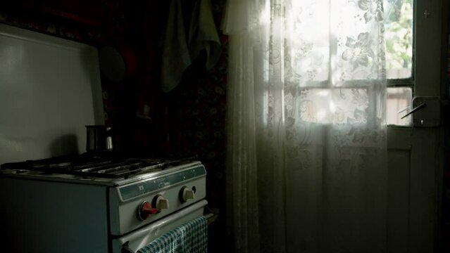 Old stove by the window in old dark kitchen, rural lifestyle ambience