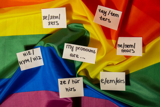 MY PRONOUNS ARE Neo pronouns concept. Rainbow flag with paper notes text gender pronouns hie, e, ne, xe, ze, tey. Non-binary people rights transgenders. Lgbtq community support assume my gender