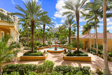 Naples, Florida Luxury Living Community with Large Palm Trees on a Courtyard and a Fountain in the Middle - obrazy, fototapety, plakaty