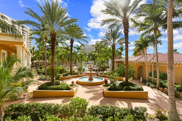 Selbstklebende Fototapete Neapel Naples, Florida Luxury Living Community with Large Palm Trees on a Courtyard and a Fountain in the Middle