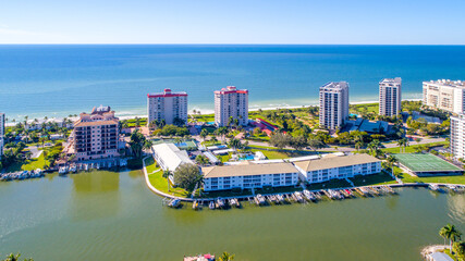Aerial Drone View of Real Estate on Bay waters in the Foreground and Low Rise Condominium Buildings...
