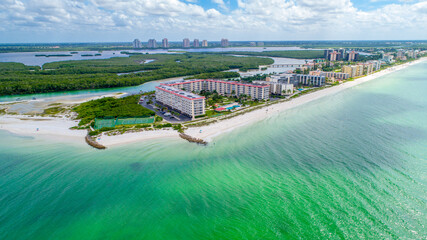 Drone Aerial View of Real Estate on Little Hickory Island in Bonita Spring, Florida with Gentle Wave Water in the Foreground and Bay Surrounded by Mangroves in the Background
