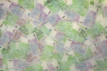 Blurred photo of one hundred and five hundred euros are defrosted in ice. The European cash currency is frozen.