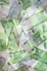 Blurred photo of one hundred and five hundred euros are defrosted in ice. The European cash currency is frozen.