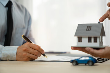 businessman holding a pen Sign to buy, sell or rent. Insurance takes care of real estate services. and the concept of a real estate agent offering interest in installments to their clients.