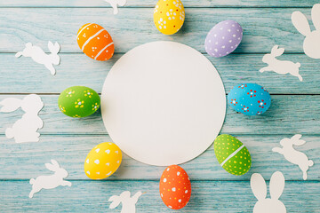 Easter Day Concept. Flat lay holiday banner background web design white colorful easter eggs composition with paper round blank on blue wood background with empty copy space, celebration greeting card
