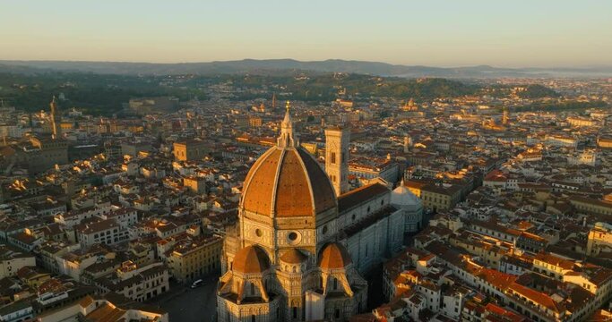 Aerial Forward Tilt Down Shot Of Famous Historical Landmark Amidst Houses In City During Sunset - Florence, Italy