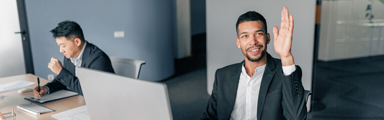 Young worker raise his hand up to ask a question to business team leader