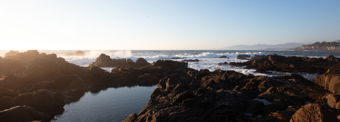 Tide pool at rocky central California coastline during golden hour at Cambria California United...
