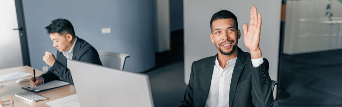 Young worker raise his hand up to ask a question to business team leader