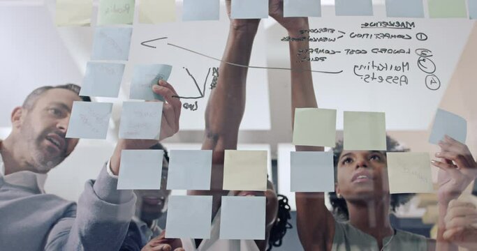 Timelapse of planning, brainstorming or business people with strategy or teamwork on glass wall in meeting. Diversity, sticky notes or creative group talking or writing ideas for our vision together