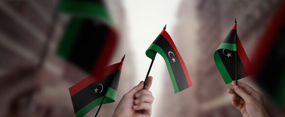 A group of people holding small flags of the Libya in their hands